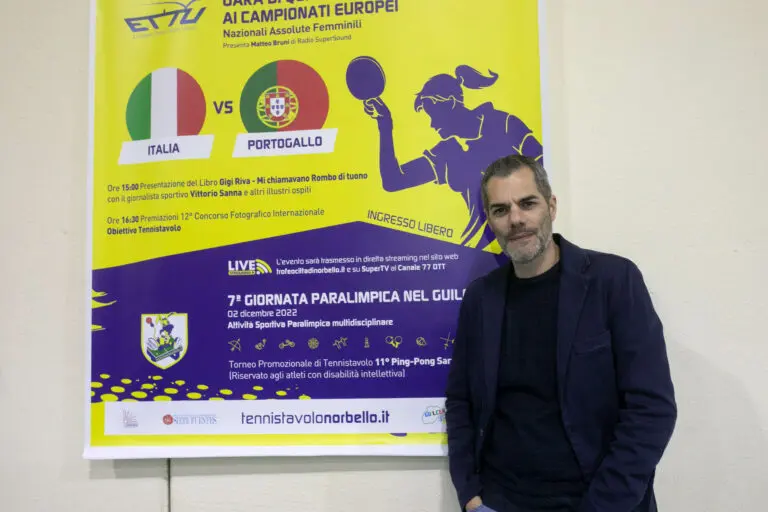 Simone Carrucciu accanto alla locandina di Italia-Portogallo e della Giornata Paralimpica